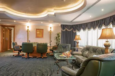 a living room with a couch and chairs and a table at Bristol Hotel in Amman