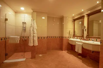 a large bathroom with two sinks and two mirrors at Bristol Hotel in Amman