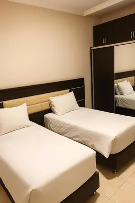 a bedroom with two beds and a mirror at Panda Hotel Apartments in Amman