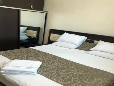 a hotel room with two beds and a mirror at Panda Hotel Apartments in Amman