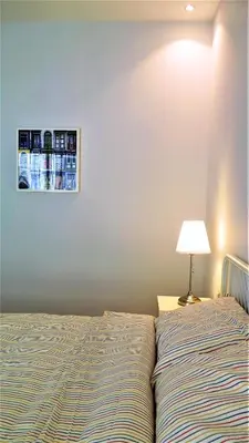 a bedroom with a bed with a lamp next to it at Double Key by HR in Amman