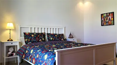 a bedroom with a large bed with colorful sheets and pillows at Double Key by HR in Amman