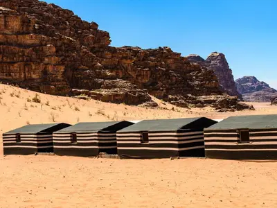 a group of buildings sitting in the desert at Bedouin life Camp in Wadi Rum