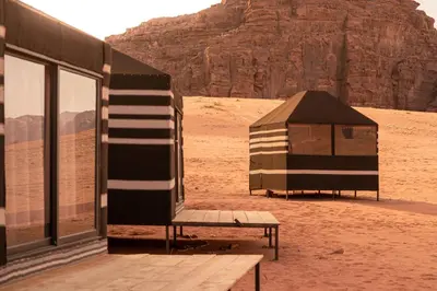 a tent and a bench in the desert at Desert Bird Camp in Wadi Rum