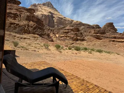a chair sitting on a deck in the desert at Wadi Rum Desert Secret in Wadi Rum