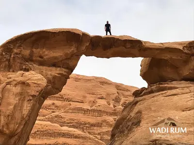 a man standing on top of a bridge in the desert at Wadi Rum Starlight Camp in Wadi Rum