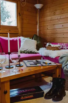a living room with a couch and a table with wine glasses at Mountain Breeze Lodge & Resort in Al Salt