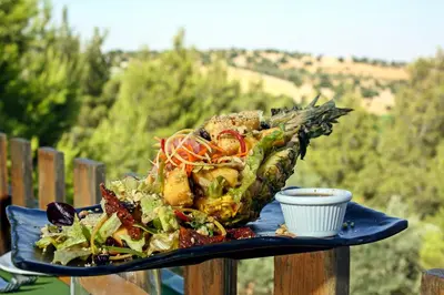 a plate of food with a salad on a table at Mountain Breeze Lodge & Resort in Al Salt