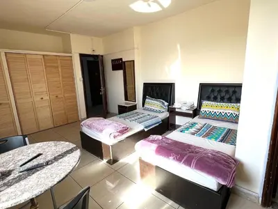 a living room with two beds and a table at Al Qatal Building in Al Qasţal