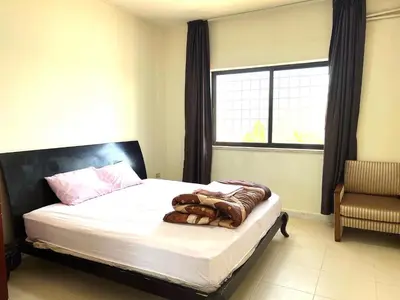 a bedroom with a bed with white sheets and a window at Al Qatal Building in Al Qasţal
