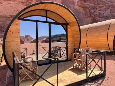 a dome tent with chairs in the desert at Wadi Rum Quiet Village Camp in Wadi Rum