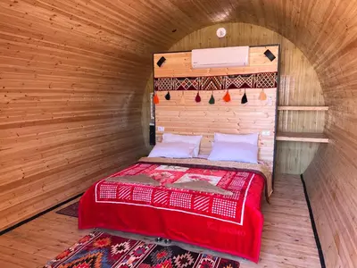 a bedroom with a bed in a wooden room at Wadi Rum Quiet Village Camp in Wadi Rum