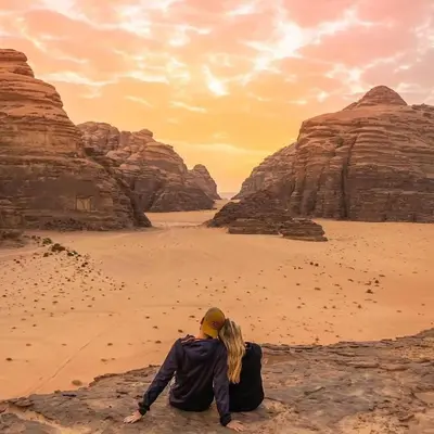a couple sitting in the desert watching the sunset at Wadi Rum Dream Camp in Wadi Rum