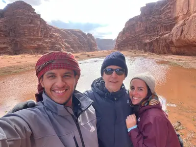 a group of three people standing in front of a river at Raka Camp & Tours in Wadi Rum