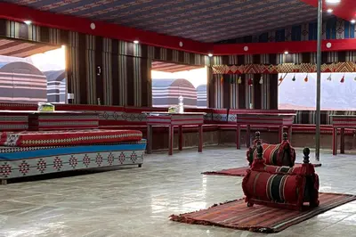 a room with red chairs and tables in a building at Welcome to Wadi Rum Camp in Wadi Rum