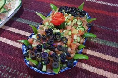 a salad in a blue bowl on a table at Welcome to Wadi Rum Camp in Wadi Rum
