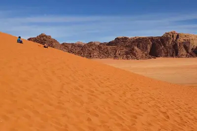 two people standing on a sand dune in the desert at Welcome to Wadi Rum Camp in Wadi Rum