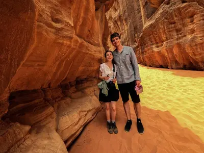 a man and woman standing in a slot canyon at Stargazing Camp & Tours in Wadi Rum