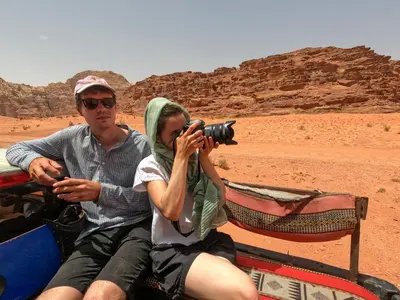 a man and a woman taking a picture in the desert at Stargazing Camp & Tours in Wadi Rum