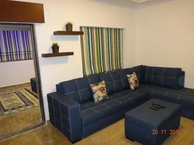 a living room with a blue couch and a mirror at Royal Luxury Apartments & Studios 2 in Amman