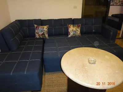 a blue couch with a table in a living room at Royal Luxury Apartments & Studios 2 in Amman