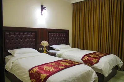 a hotel room with two beds and a window at Qaser Al-Sultan Hotel Suites in Amman