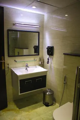 a bathroom with a sink and a mirror at Qaser Al-Sultan Hotel Suites in Amman