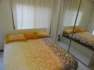 a bedroom with a bed with orange pillows and a mirror at Diyarkom Apartment in Amman