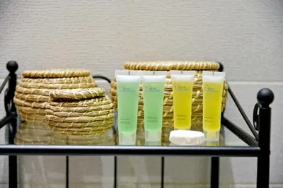 a shelf with three bottles of moisturizers and a basket at Elite Residency in Amman