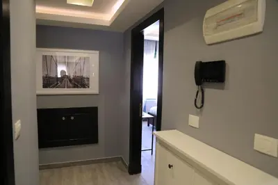 a hallway with a television and a phone on a wall at Elite Residency in Amman