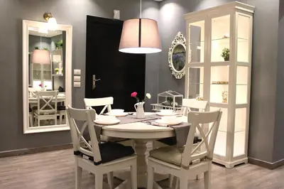 a dining room with a table and chairs and a mirror at Elite Residency in Amman