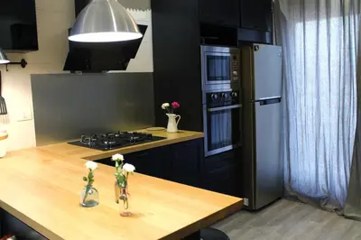a kitchen with a counter with a stove and a refrigerator at Elite Residency in Amman