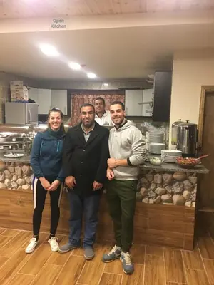 a group of people posing for a picture in a kitchen at Petra Cabin Inn Hostel&Resturant in Wadi Musa