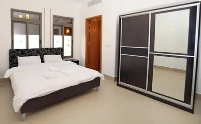 a bedroom with a large bed and a large mirror at Tala Bay Residence - Families Only in Aqaba