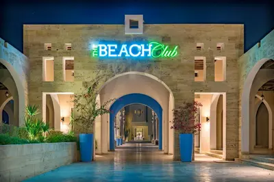 a building with a sign that reads the beach club at Tala Bay Residence - Families Only in Aqaba