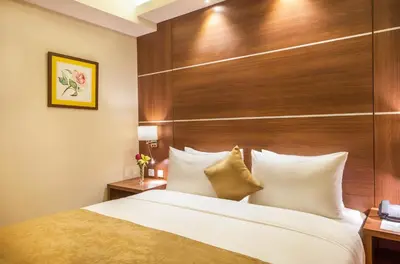 a bedroom with a large bed with a wooden headboard at Gerasa Hotel in Amman