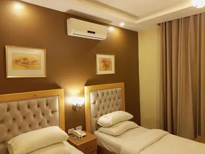 a hotel room with two beds and a air conditioner at Mariam Hotel in Madaba