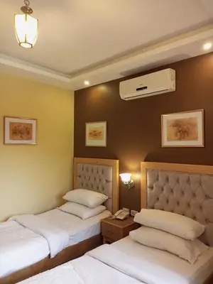 a hotel room with two beds and a air conditioner at Mariam Hotel in Madaba