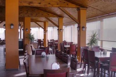 a restaurant with wooden tables and chairs and tables and tablesearcher at Mariam Hotel in Madaba