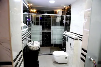 a black and white bathroom with a toilet and a shower at Petra Sella Hotel in Wadi Musa