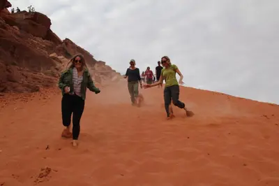 a group of people walking in the sand at Wild of Wadi Rum in Wadi Rum