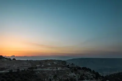 a view of the sunset from the top of a mountain at Beit Al Baraka in Um Qeis