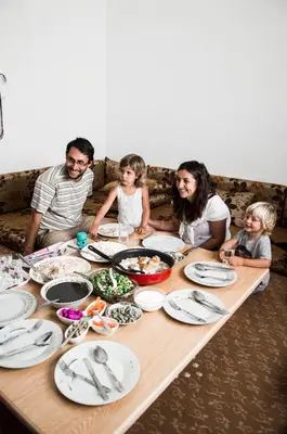 a group of people sitting around a table with food at Beit Al Baraka in Um Qeis