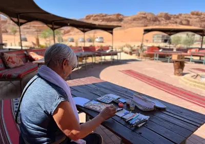 a man sitting at a picnic table in front of a picnic table at Rum Planet Camp in Wadi Rum