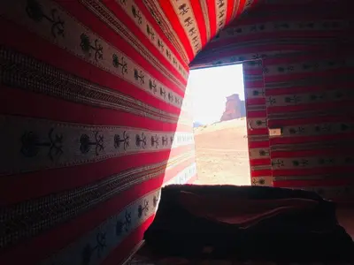 a room with a wall with a window in the desert at Red Mountain Camp in Wadi Rum