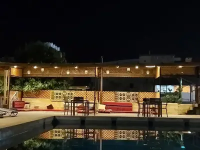 a house with chairs and a pool at night at Darna Divers Village in Aqaba