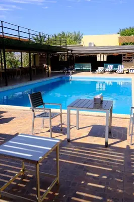 a table and chairs next to a swimming pool at Darna Divers Village in Aqaba
