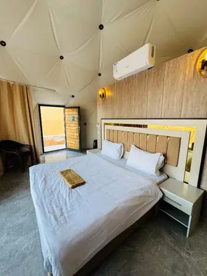 a bedroom with a large bed in a tent at DESERT HELO lUXURY CAMP & TOUR in Wadi Rum