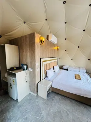 a bedroom with a large bed in a tent at DESERT HELO lUXURY CAMP & TOUR in Wadi Rum