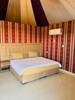 a bed in a room with a red wall at DESERT HELO lUXURY CAMP & TOUR in Wadi Rum